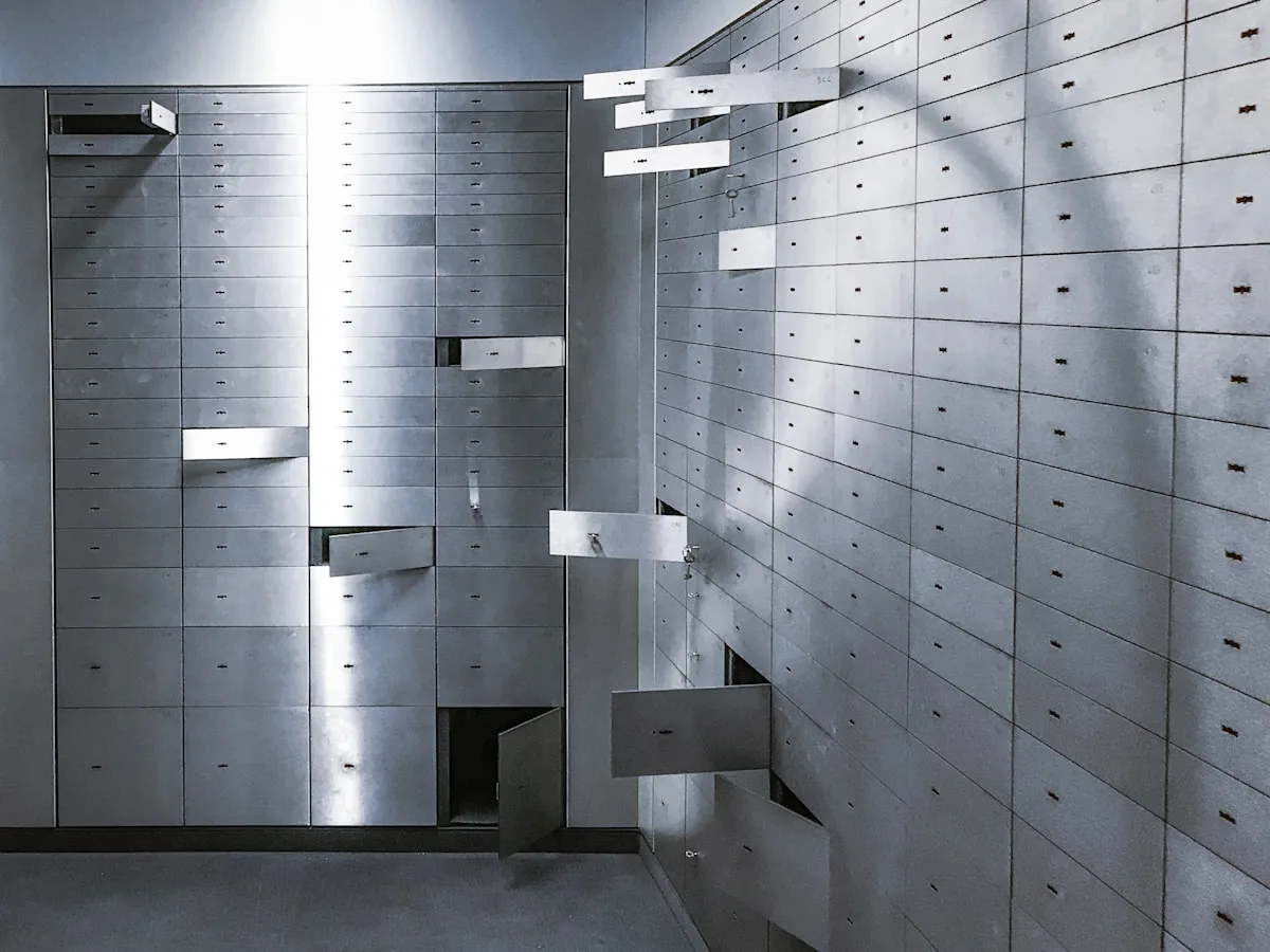 A bank vault room lined with rows of safe deposit box drawers, showcasing the secure storage infrastructure that has served investors for over a century