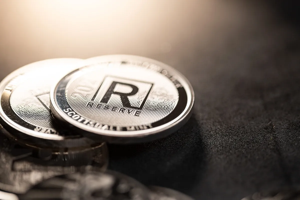Two silver coins resting on a dark surface, representing the precious metals that require careful authentication to protect against counterfeits