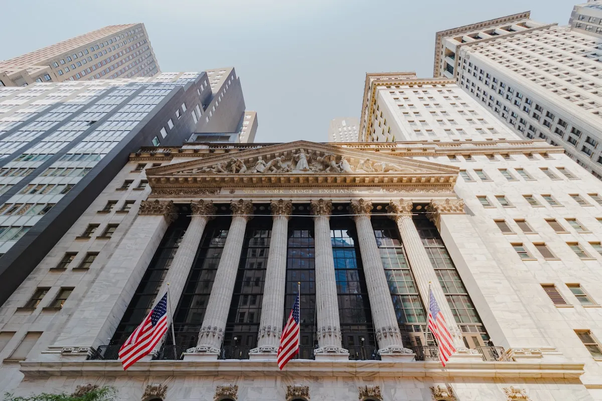 Financial district skyscrapers reaching into the sky — gold prices are shaped by the same global forces that move the world’s largest markets