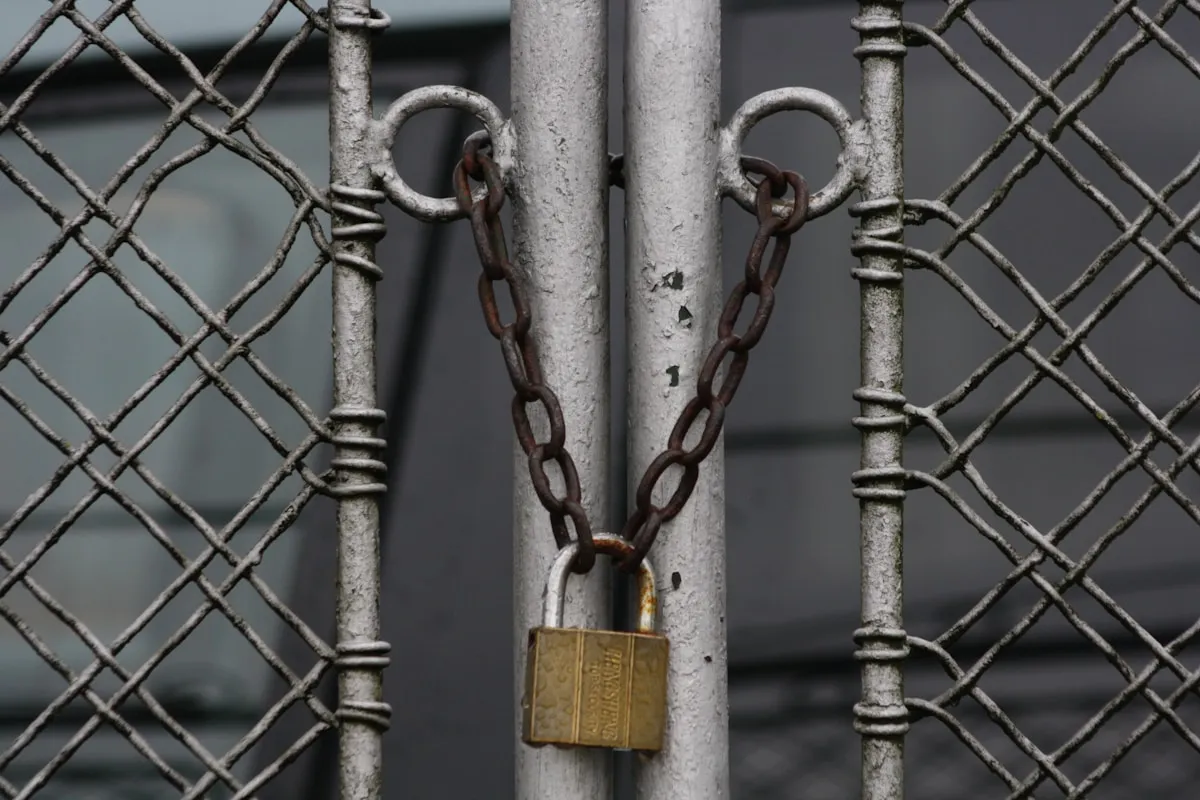A heavy chain and padlock securing a metal gate — a visual metaphor for government restrictions on private gold ownership