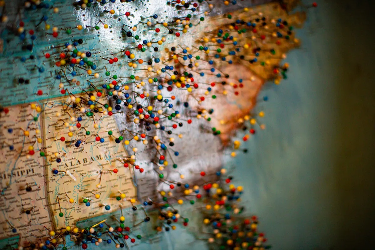 Colorful US map with pins representing the geographic diversity of economic forces affecting the dollar-gold relationship